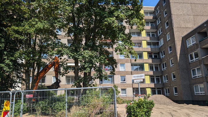 Ein Bauzaun und ein Wohnhaus