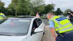 Ein Polizist kontrolliert einen Autofahrer