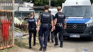 Polizeibeamte vor Ort vor einem Polizeiauto.