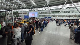 Fluggäste warten am Flughafen in Düsseldorf 