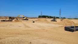 Mehrere Bagger auf einer großen Fläche verteilt mit mehreren Erdwällen