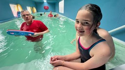 Julia und ein Bademeister im Schwimmcontainer.