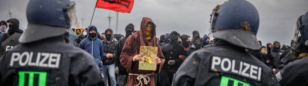 Ein als Mönch verkleideter Mann bei den Lützerath-Protesten