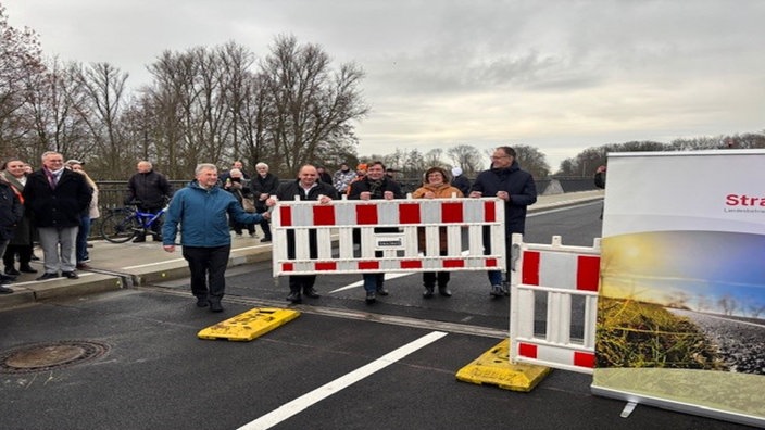 Menschen bauen die Brückensperrung ab