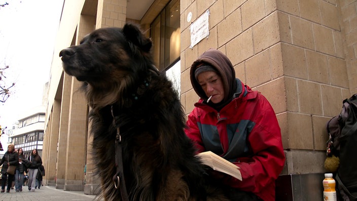 Die Obdachlose Melanie sitzt mit ihrem Hund Filou in der Bonner Innenstadt.