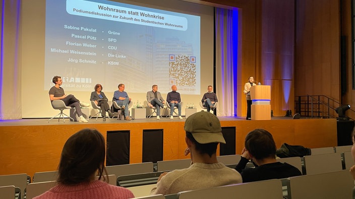 Bei der Podiumsdebatte wird über die Wohnkrise der Studierenden in Köln gesprochen