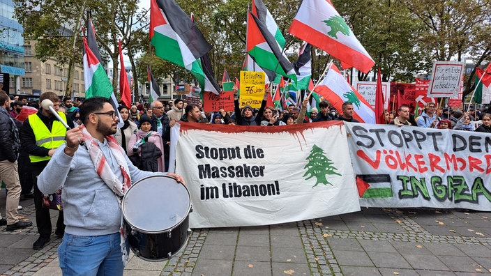 Eine Menschenmenge auf dem Kölner Neumarkt, viele mit Palästina-Flaggen und Schildern mit Kritik am Militäreinsatz Israels