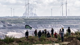 Demonstranten stehen an der Abrisskante zum Tagebau