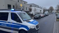 Ein Polizeiauto steht vor einer Wohnsiedlung.