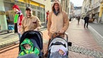 Zwei verkleidete Männer mit Kinderwagen.