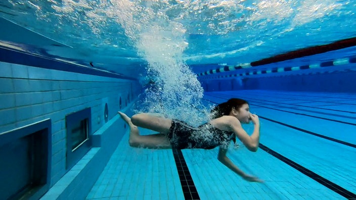 Schwimmerin unter Wasser in einem Schwimmbadbecken