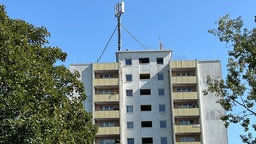 Ein Wohnhaus, auf dessen Dach Mobilfunkmasten zu sehen sind