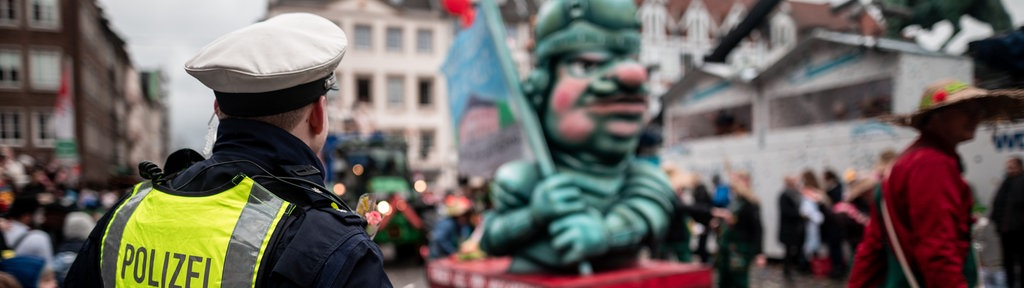 Ein Polizist bewacht den Rosenmontagszug in Düsseldorf