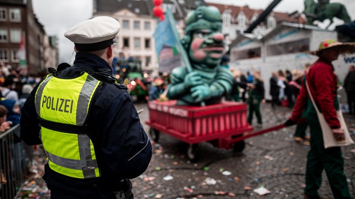 Ein Polizist bewacht den Rosenmontagszug in Düsseldorf