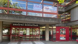Eingang der Zentralbibliothek in der Kölner Innenstadt. Im Fenster hängt ein Banner mit dem Hinweis, dass der Standort zum 01.07. voerst schließt.
