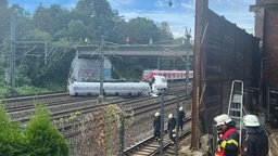 Sattelschlepper liegt auf Bahngleisen vor einer S-Bahn