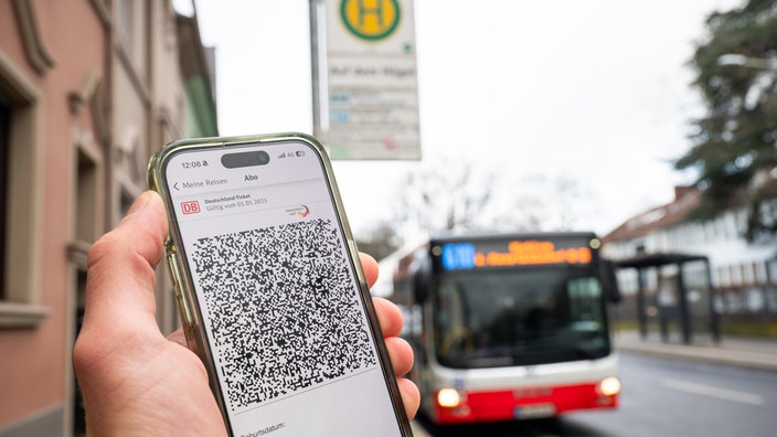 Ein digitales Deutschlandticket vor einem Bus der Stadtwerle Bonn. Ticket ist verfremdet!