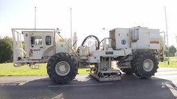 Einer der speziell ausgerüsteten Trucks von der Seite. Der Wagen sendet Schallwellen in den Boden aus. Die verschiedenen Erdschichten reflektieren den Schall unterschiedlich stark.