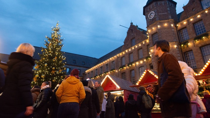 Der Düsseldorfer Weihnachtsmarkt mit Tannenbaum links im Bild und roten Büdchen.