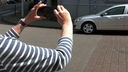 Frau fotografiert parkendes Auto