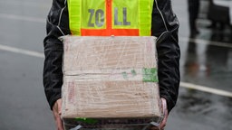 Ein Zollbeamter hält ein Paket.