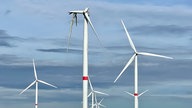 Zu sehen ist der Windpark Zülpich-Wichterich, inmitten intakter Windräder eines, an den ein Flügel hängt und unter dem Trümmerteile verstreut liegen.