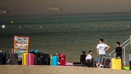 Menschen stehen am Strand und warten auf Rettung