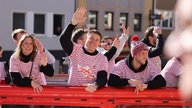 Die Fußballer Dominique Heintz und Luca Waldschmidt fahren auf dem Wagen des 1. FC Köln mit