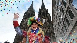 Eine bunt verkleidete Karnevalistin vor dem Dom am Rosenmontag