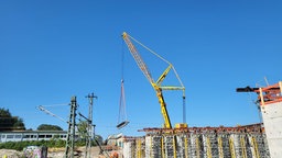 Schweret Beton an Seilen vor Brücke