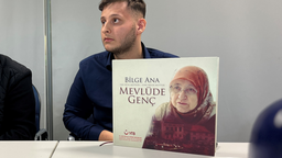 Foto Familie 3 - Can Genc vor Gedenkbuch zu Mevlüde Genc