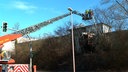 Eine Feuerwehr-Drehleiter mit Einsatzkräften im Korb löschen einen Brand. 