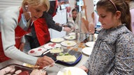 Uschi Glas verteilt die Brotzeit an Kinder einer Essener Grundschule