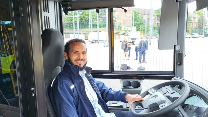 Ein Mann sitzt im Bus am Steuer