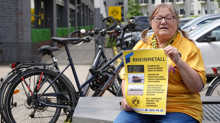 Ein BVB-Fan protestiert mit einem Plakat in der Hand