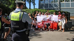 Ein Polizist des Kommunikationsteam macht Fotos von polnischen Fans