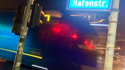 Straßenschild "Hafenstraße" in Essen mit einem vorbeifahrenden LKW im Hintergrund 