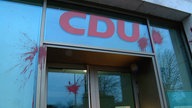 Über einer Glastür steht in roter Farbe das CDU-Logo. Auf dem Glas und an der Fassade sind rote Farbflecken zu sehen