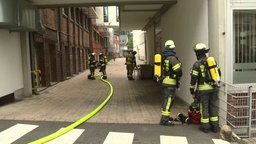 Die Feuerwehr ist vor einer Lagehalle im Einsatz.