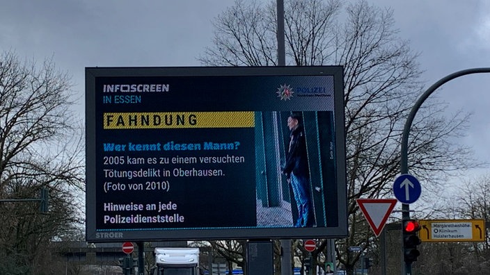 Infoscreen mit Fahndungsfoto von Oberhausener Cold Case steht an Essener Straßenkreuzung