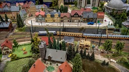 Durch eine Stadt mit alten Fachwerkhäuser fährt eine Modelleisenbahn.