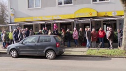 Eine größere Gruppe Menschen vor dem Kiosk in Essen