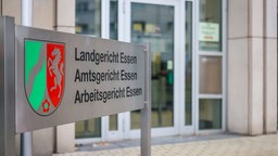 Der Eingang des Essener Landgerichts, davor ein Schild, das auf Landgericht, Amtsgericht und Arbeitsgericht verweist