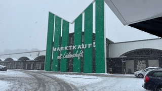 Marktkauf von außen mit vollgeschneitem Parkplatz