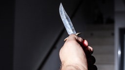 Eine Männerhand, die ein Messer hält