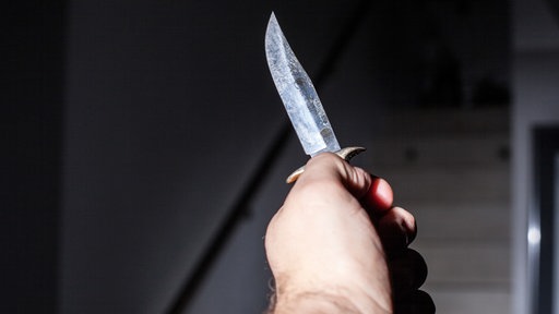 Eine Männerhand, die ein Messer hält