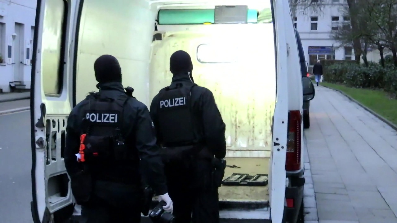 Polizisten gucken in einen Transporter bei einer Razzia gegen eine Bande, die sich im großen Stil auf den Pfandbetrug mit Obstkisten spezialisiert hat