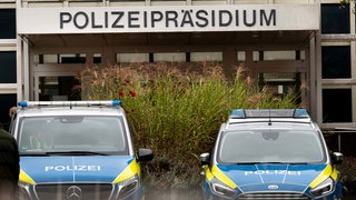 Zwei Fahrzeuge der Polizei stehen vor dem Dortmunder Polizeipräsidium.