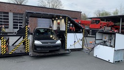 Ein Auto steht in der Spezial-Schrottpresse der Essener Feuerwehr.