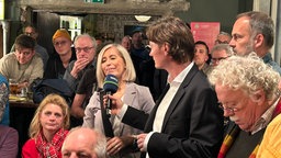 Moderator Olaf Biernat im Gespräch mit Zuschauern beim Lokalzeit Stadtgespräch zur Rüttenscheider Straße in Essen am 20.03.2025